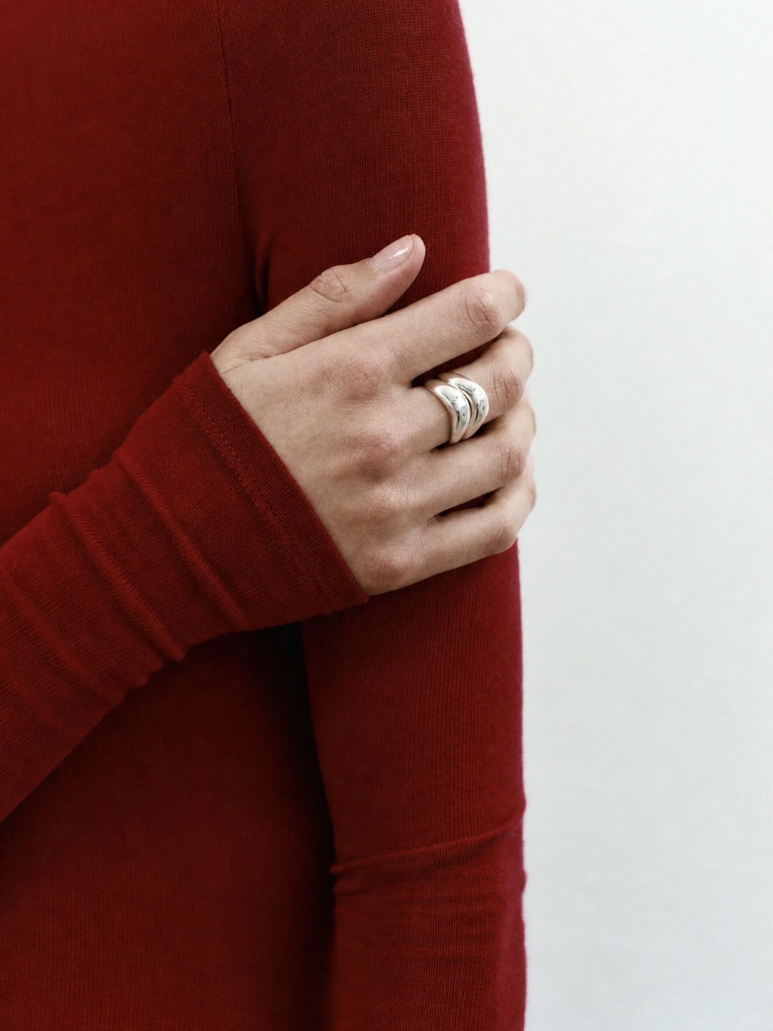 AGMES silver earrings displayed on a pink textured surface