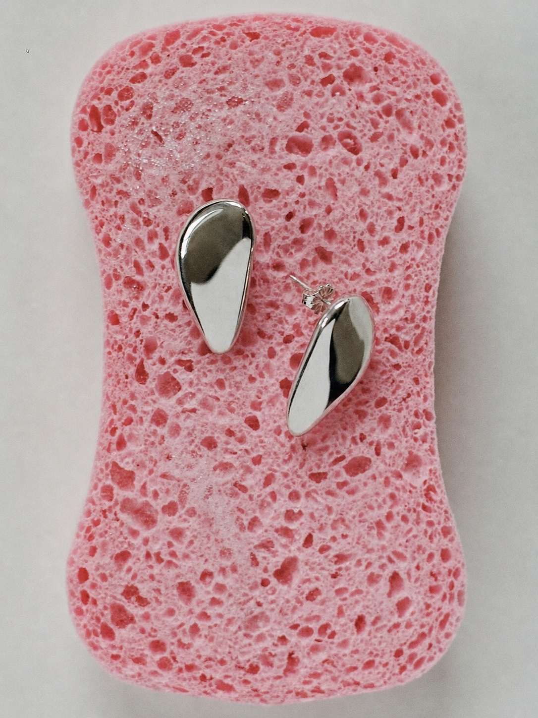 AGMES linked silver earrings in a close-up portrait