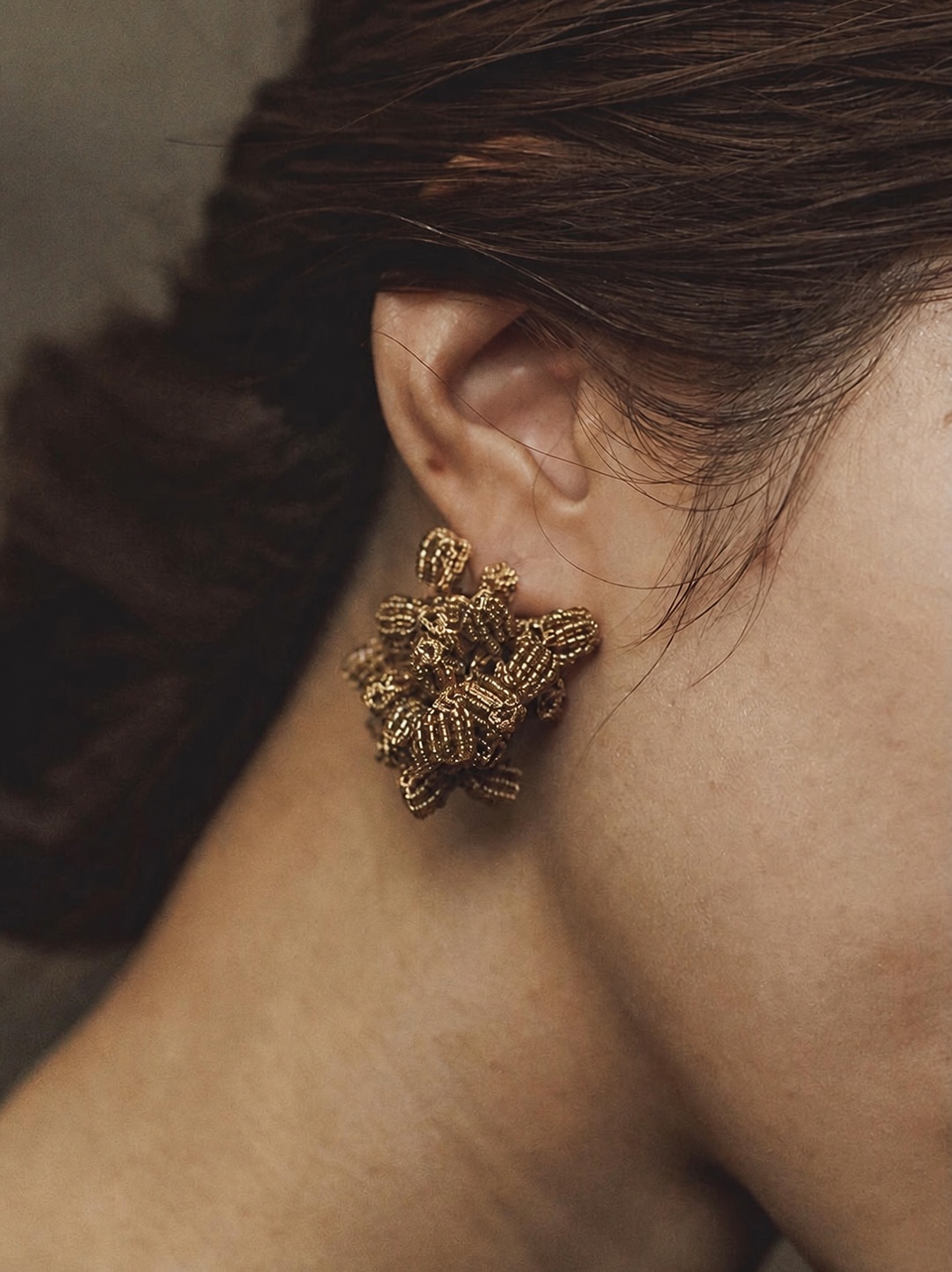 FUA gold beaded earring in a warm close-up