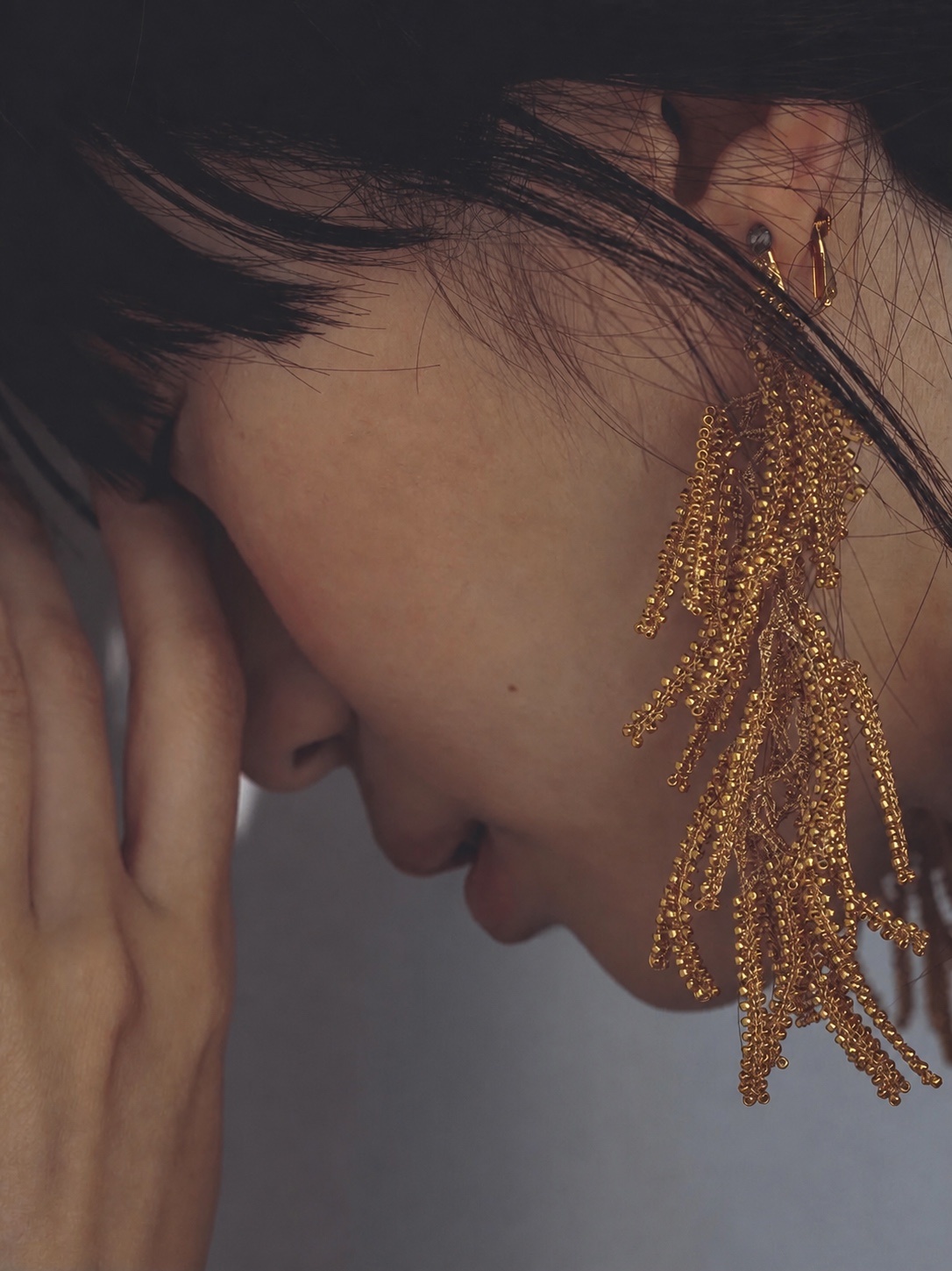 FUA gold fringe earring worn in profile