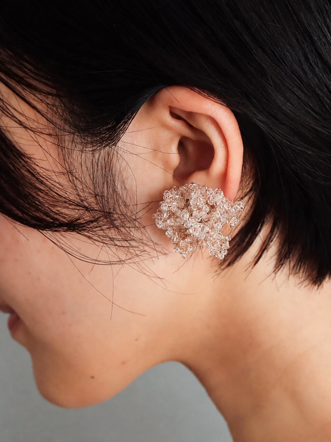 FUA clear beaded earring worn close to the ear