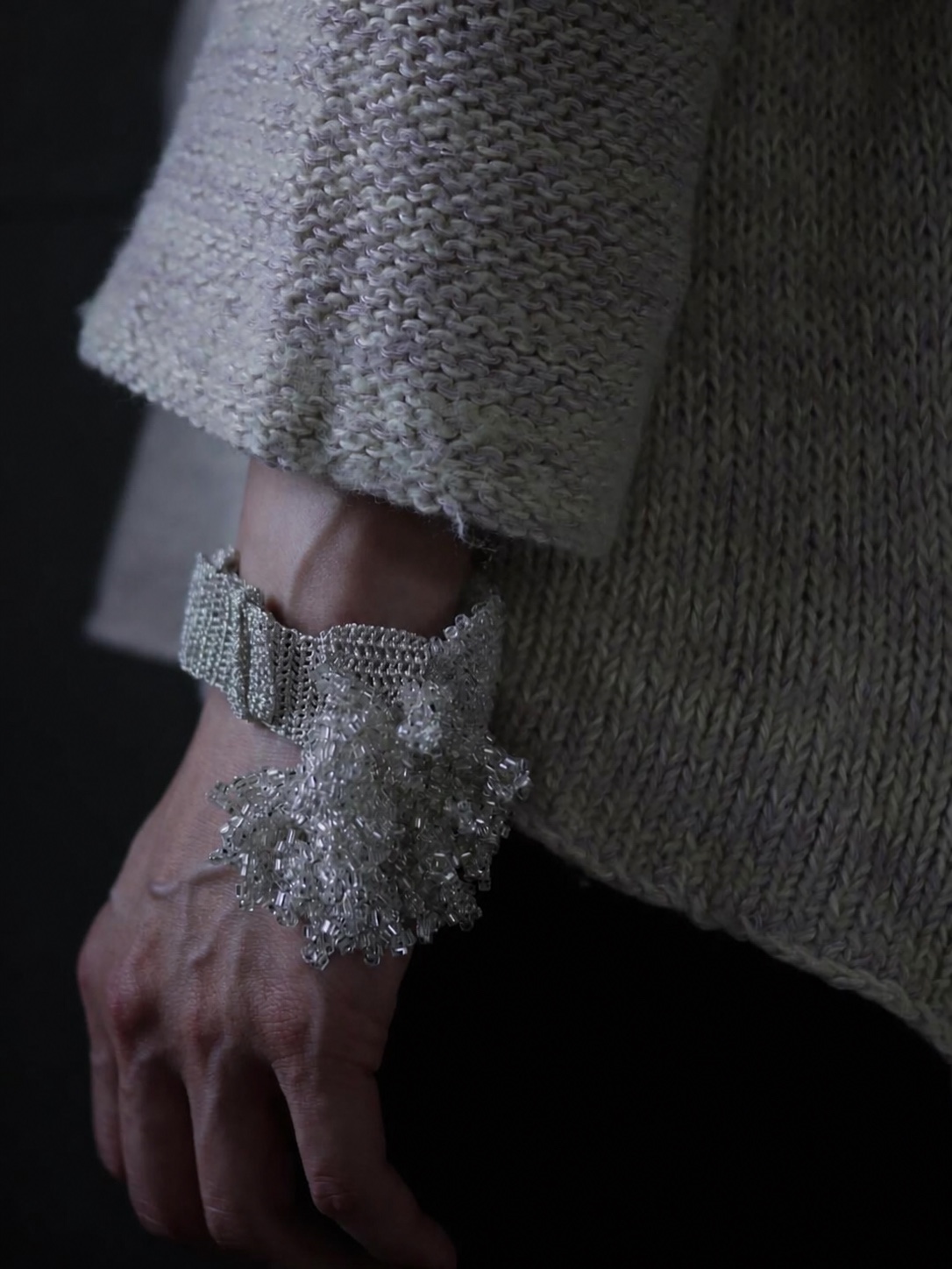 FUA beaded necklace and earrings worn with a grey top