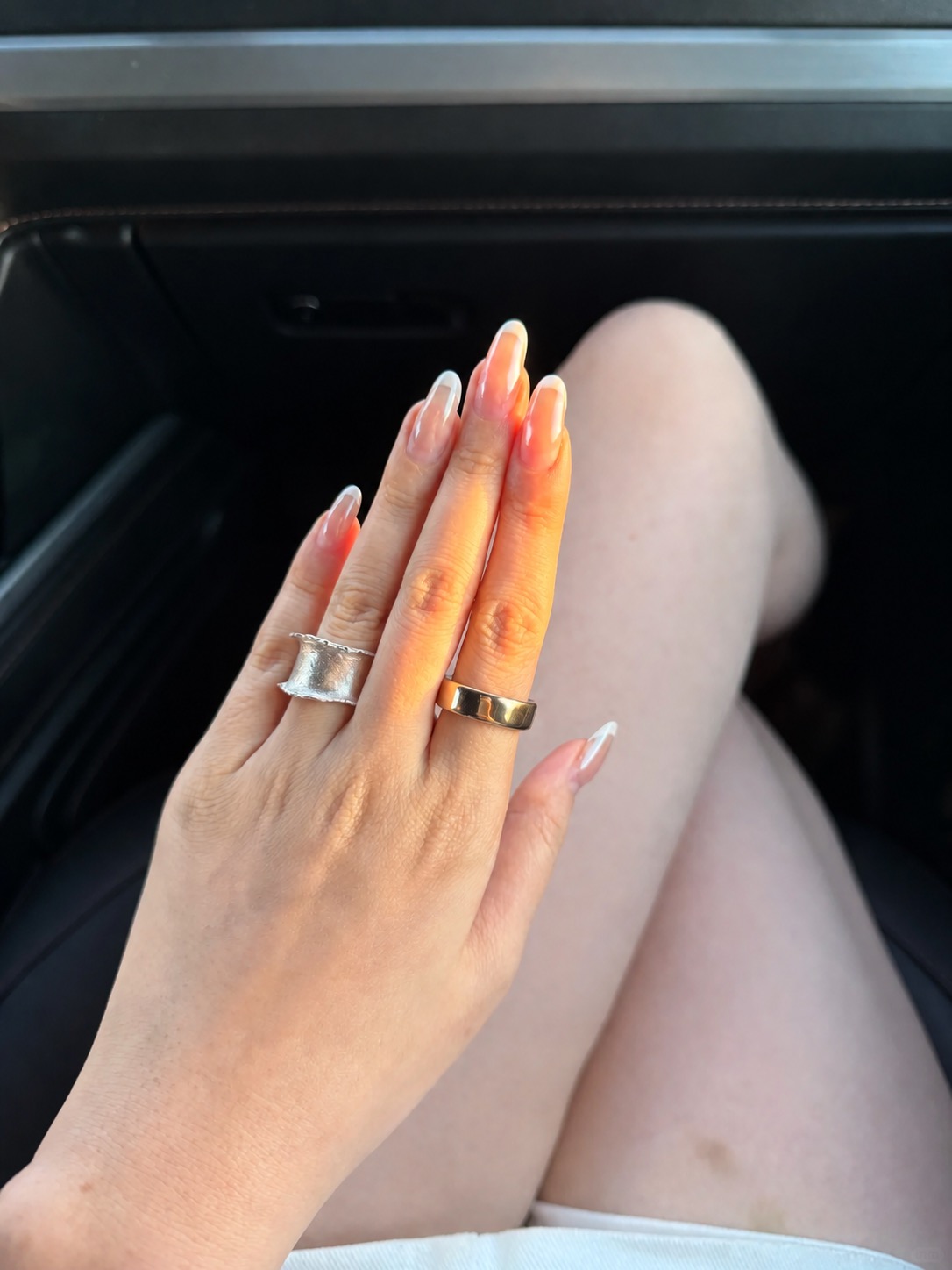 Oura Ring 5 worn as a gold smart ring in a styled hand stack