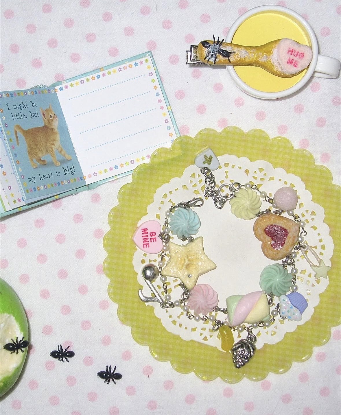 Bracelet with miniature dessert and pastel candy-like charms displayed on a yellow gingham doily.