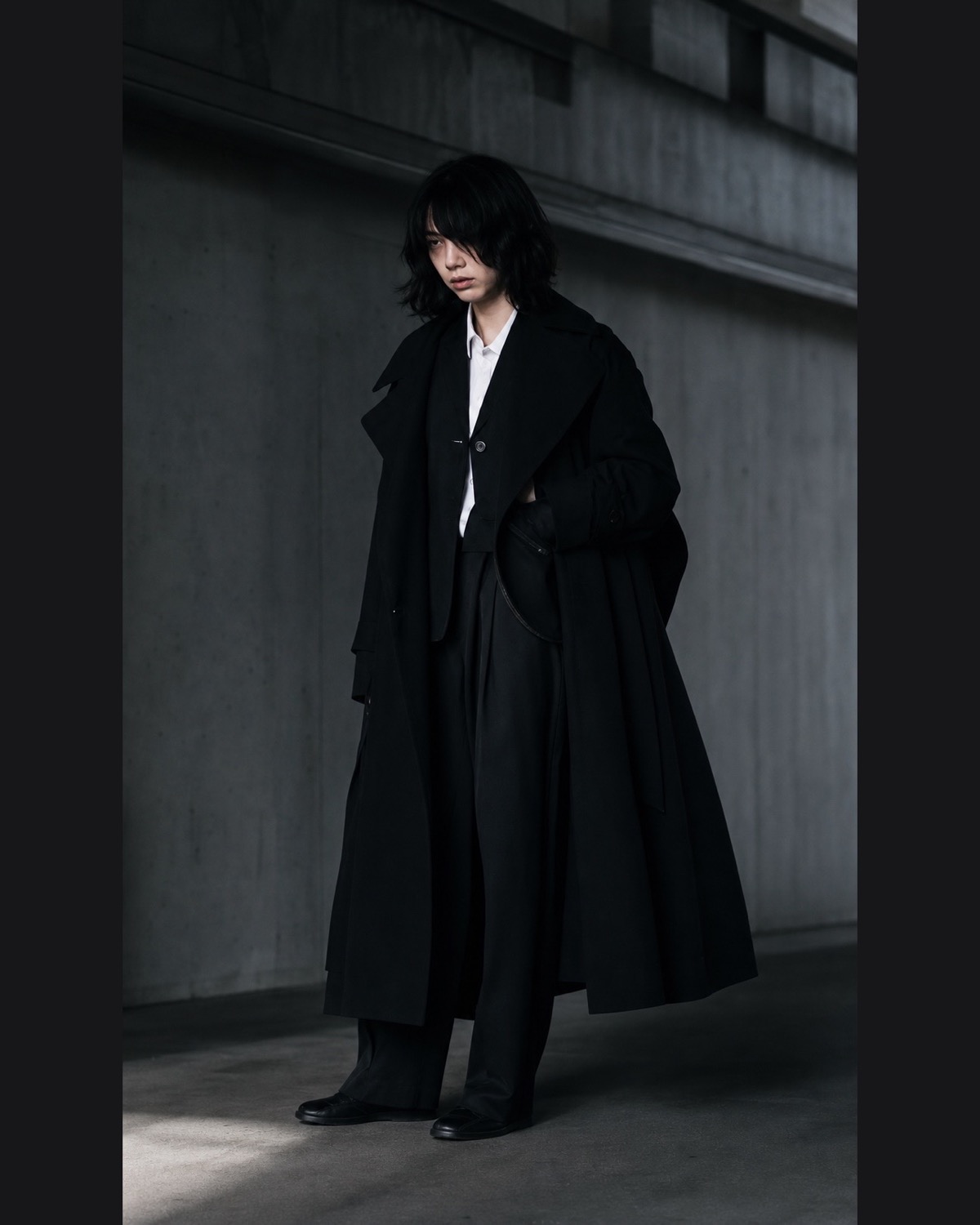 Layered black tailoring contrasts matte wool, soft drape and a crisp white collar