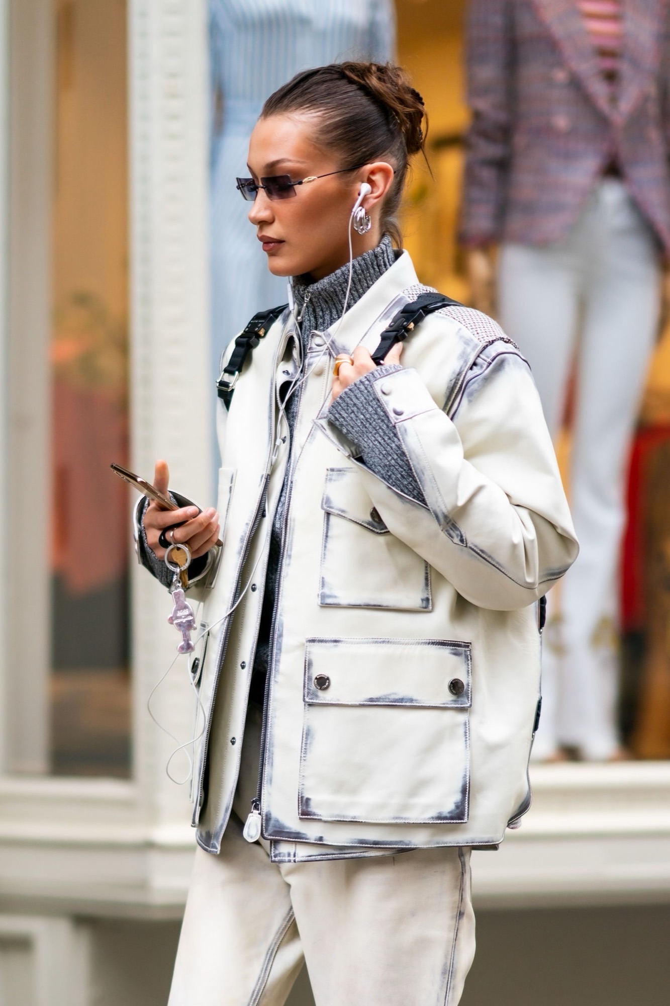 Person styling visible wired earbuds with a Y2K-inspired outfit