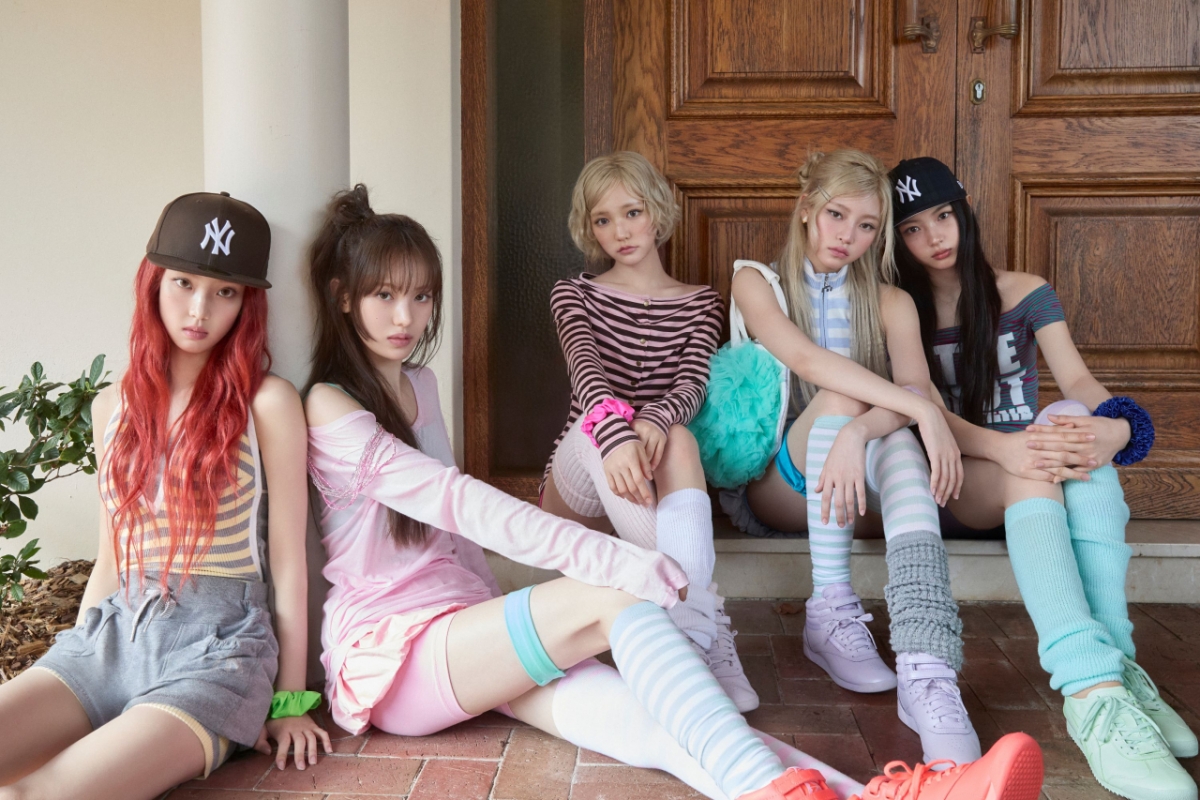 KiiiKiii members in toy-like Y2K styling with striped socks, leg warmers, and pastel sneakers