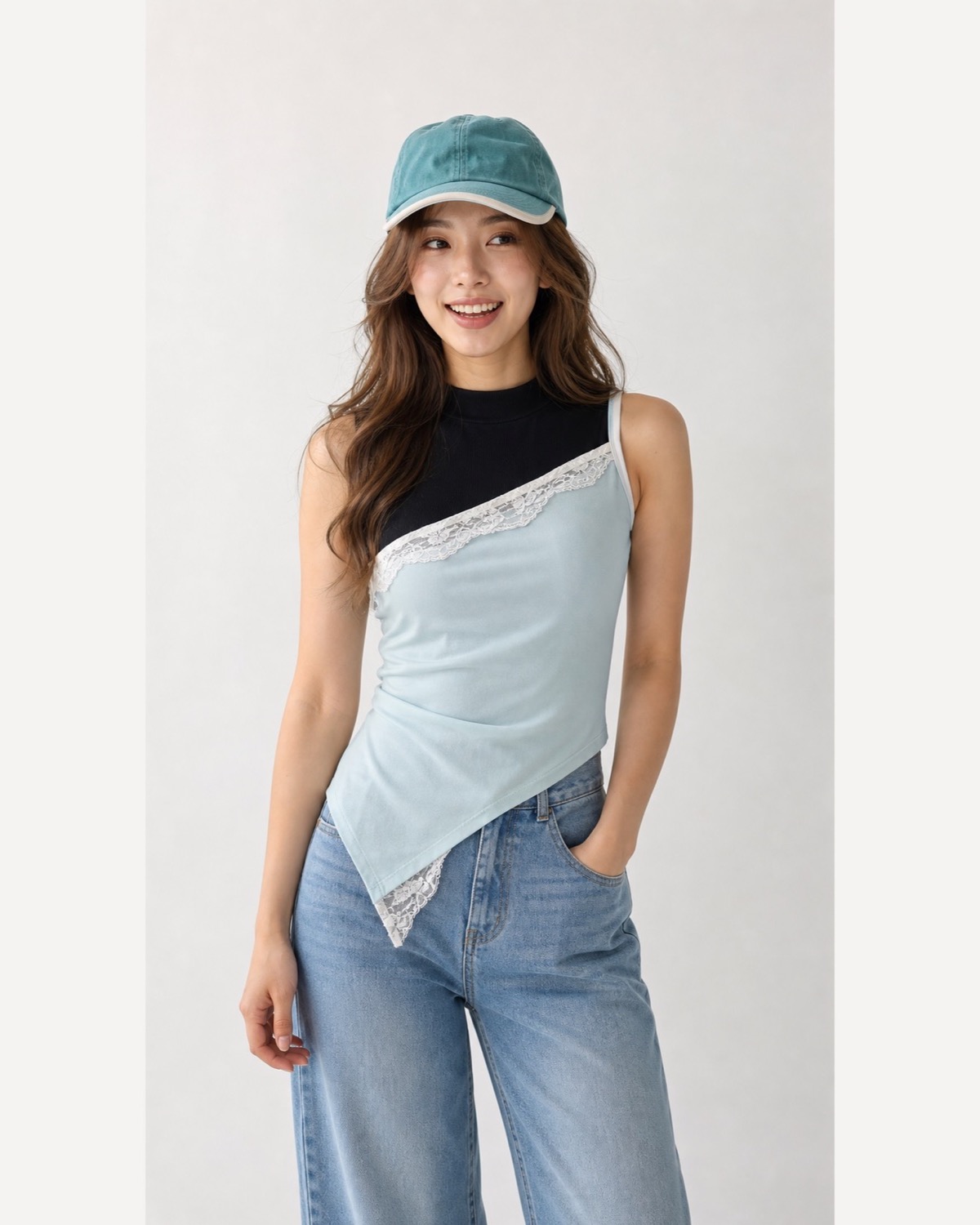 Pale-blue asymmetric top with a visible white lace edge layered over black and worn with jeans