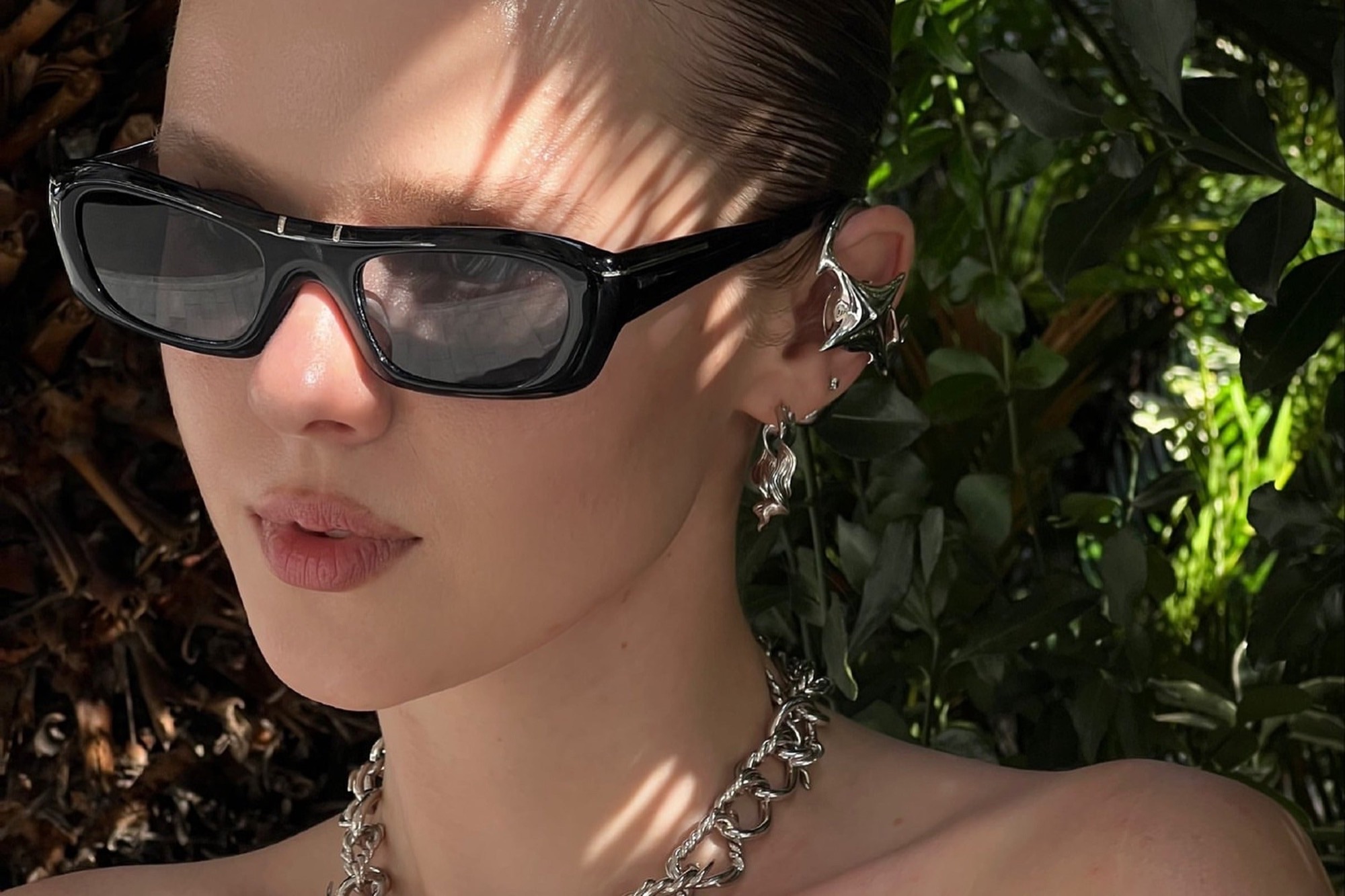Person wearing OF HUNGER Electronic Gems as a visible ear accessory outdoors