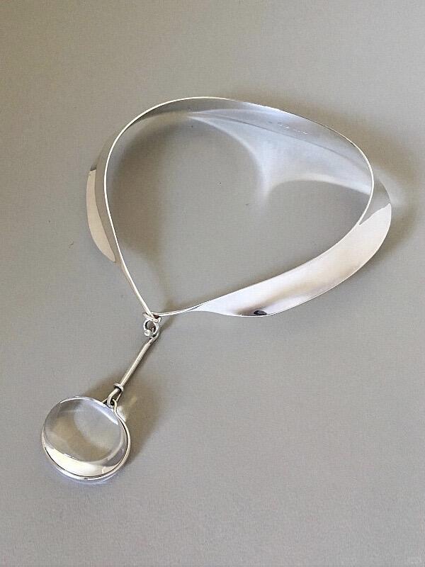 Sculptural silver Georg Jensen pendant against a grey background