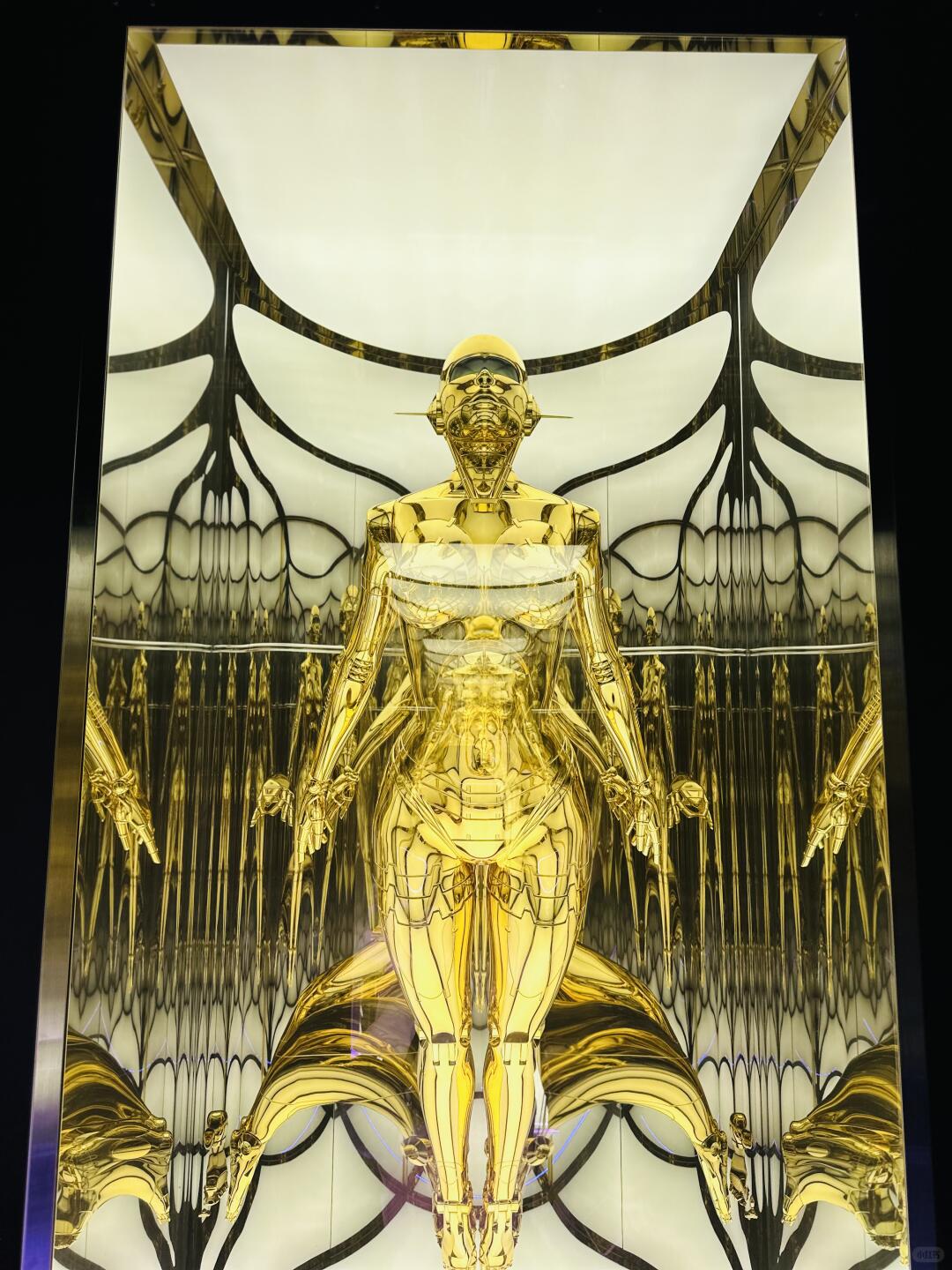 Hajime Sorayama gold chrome gynoid installation with mirrored display walls
