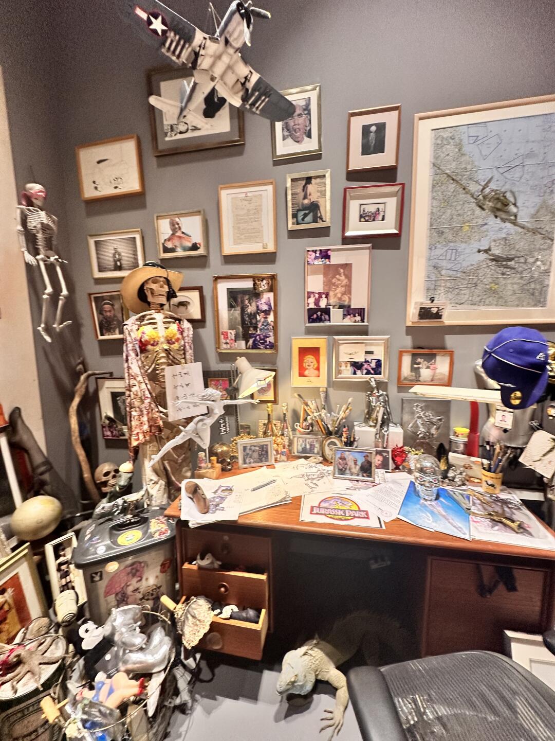 Wide studio-room view filled with mechanical art references and objects