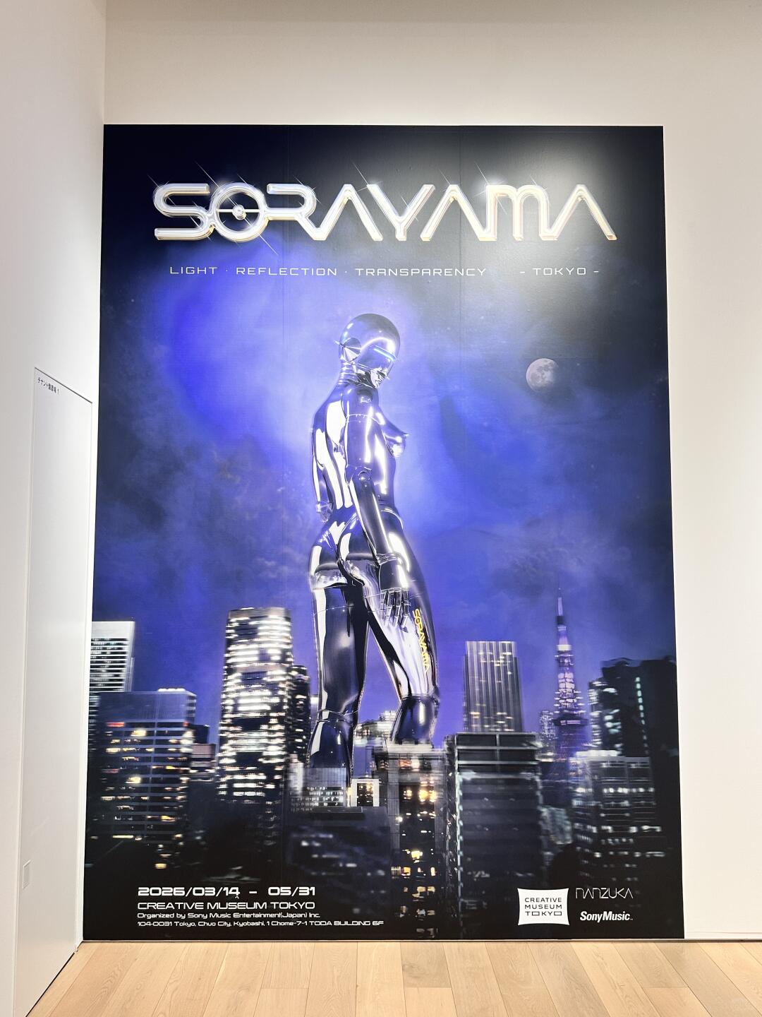Sorayama exhibition poster with chrome robot body and night city background