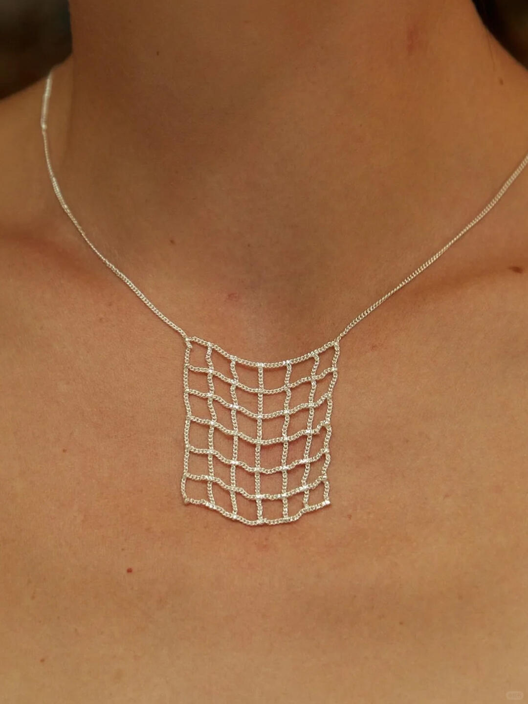 Fine silver Hannah Keefe grid pendant against skin