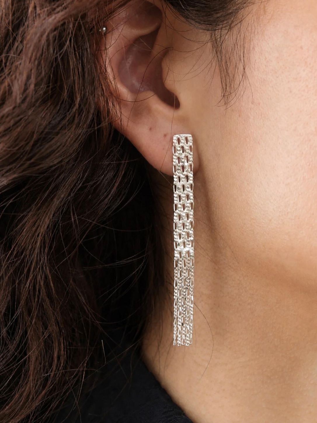 Long silver Hannah Keefe chain earring in close-up