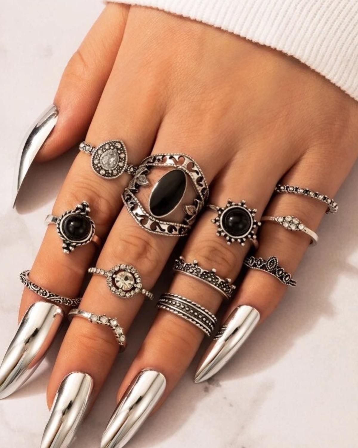 Chrome pointed nails surrounded by stacked silver-tone rings