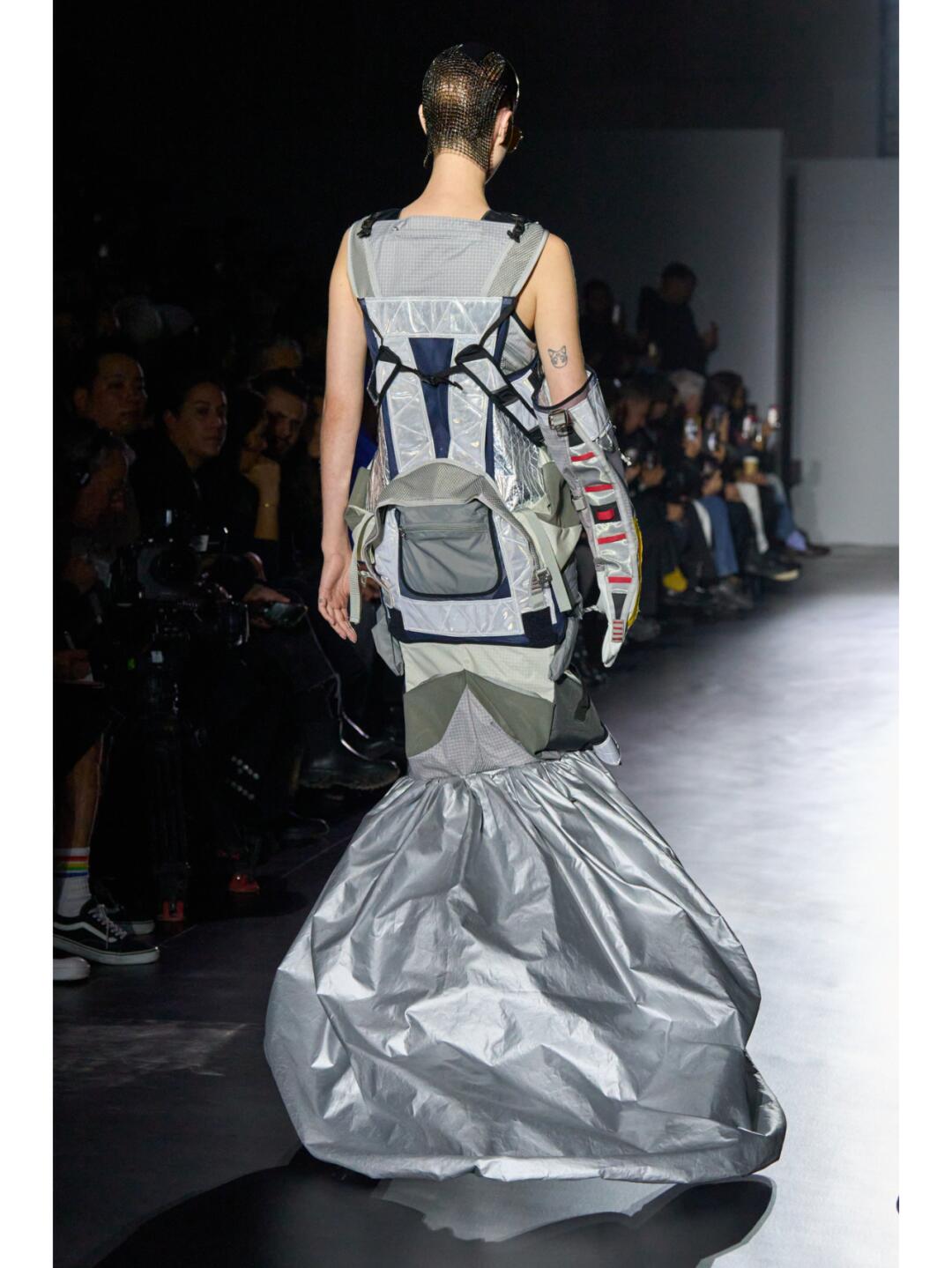Back view of a Junya Watanabe SS2025 recycled look with a silver crumpled train