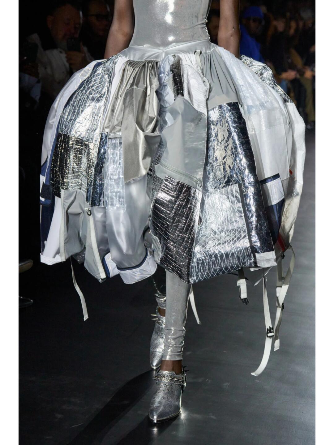 Close view of a Junya Watanabe SS2025 skirt with silver patchwork, ties and layered panels