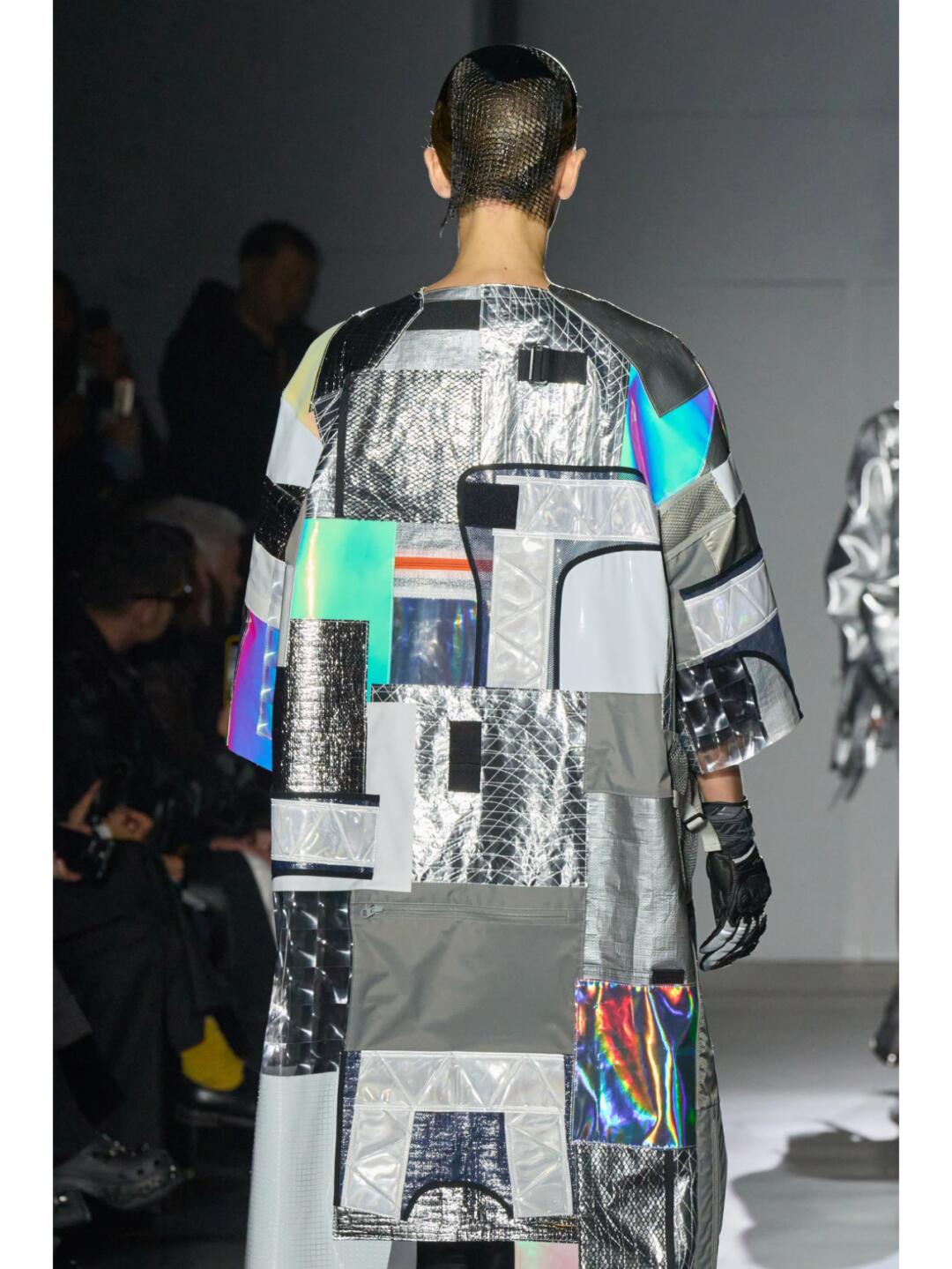Back view of a Junya Watanabe SS2025 patchwork coat with grey, black and holographic panels