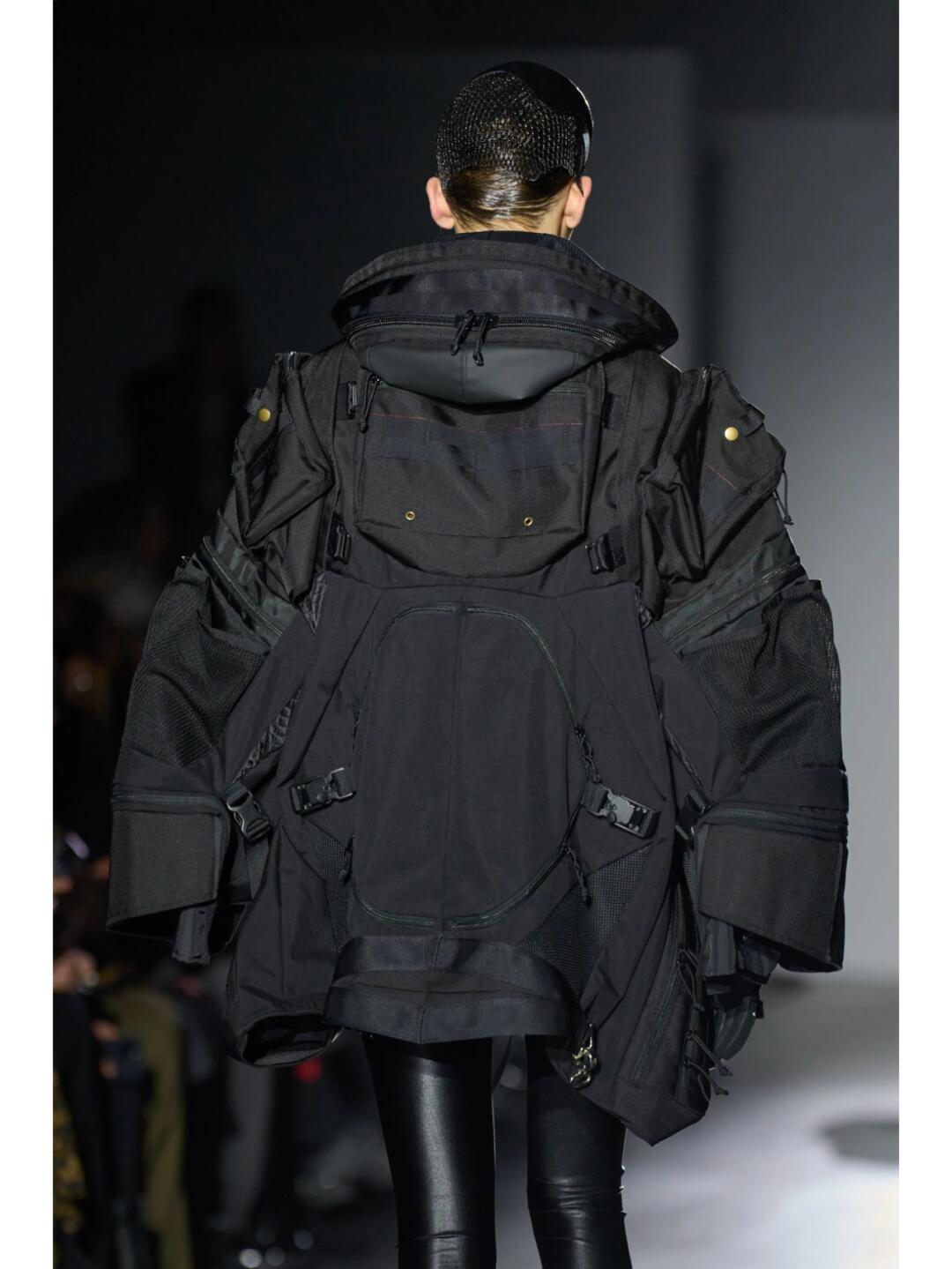 Back view of a black Junya Watanabe SS2025 technical jacket with pockets and layered volume