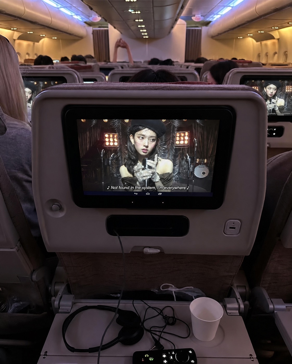 Airplane screen showing a performance in a dark cabin
