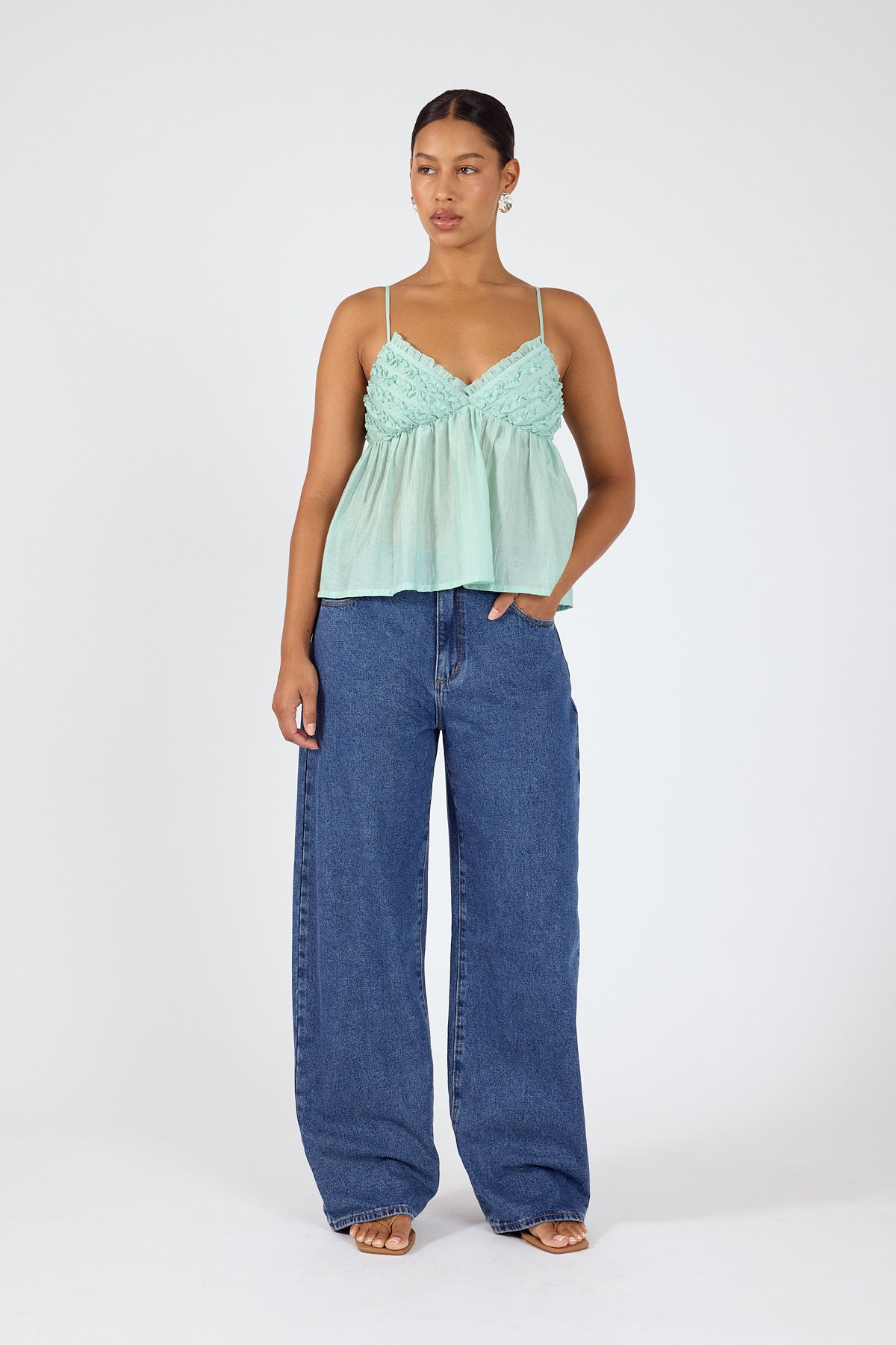 Mint green camisole styled with wide-leg blue denim jeans