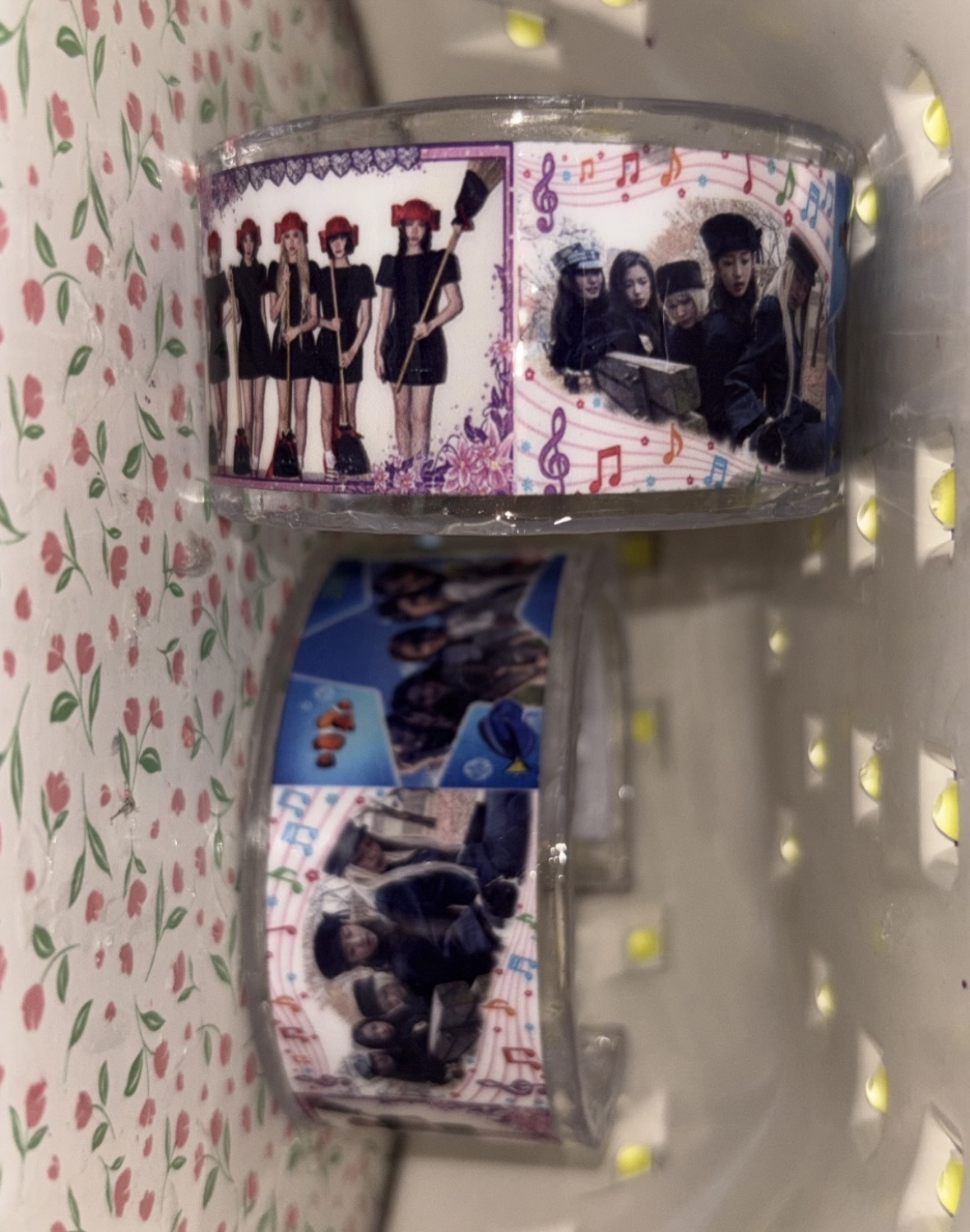 Two wide transparent cuffs decorated with group photo strips and small colorful motifs against floral fabric.