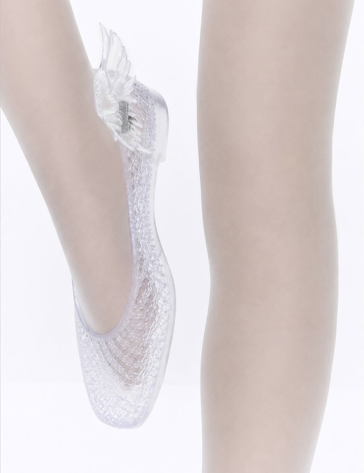 Close-up of a transparent glitter ballet flat with a wing-shaped ornament at the heel.