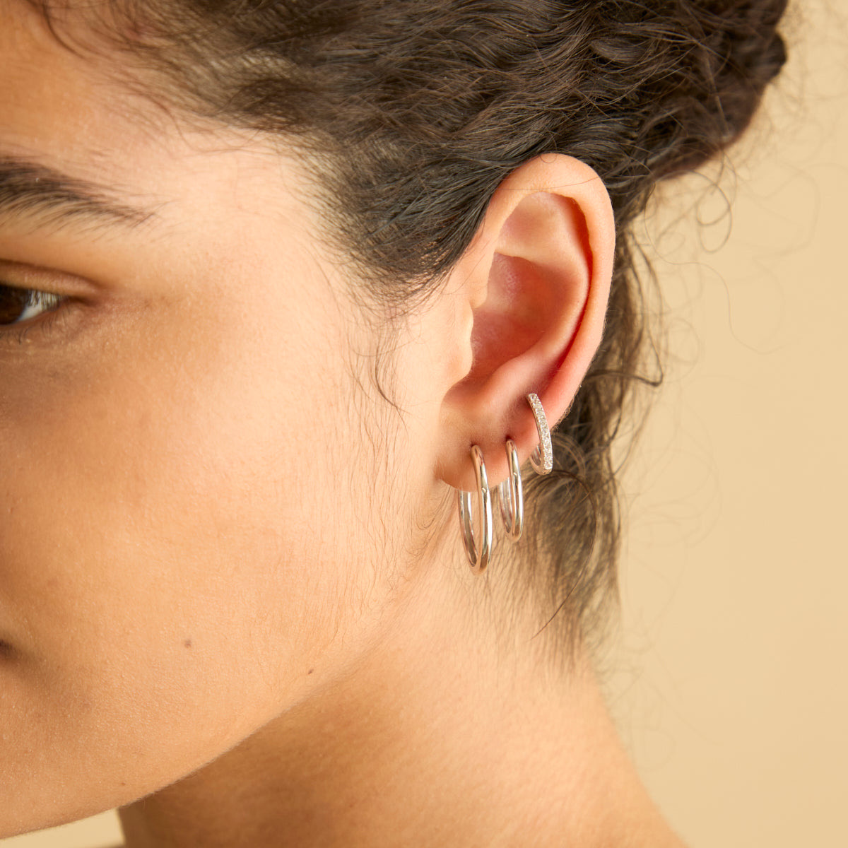 Astrid & Miyu silver hoop stacking set styled on an ear