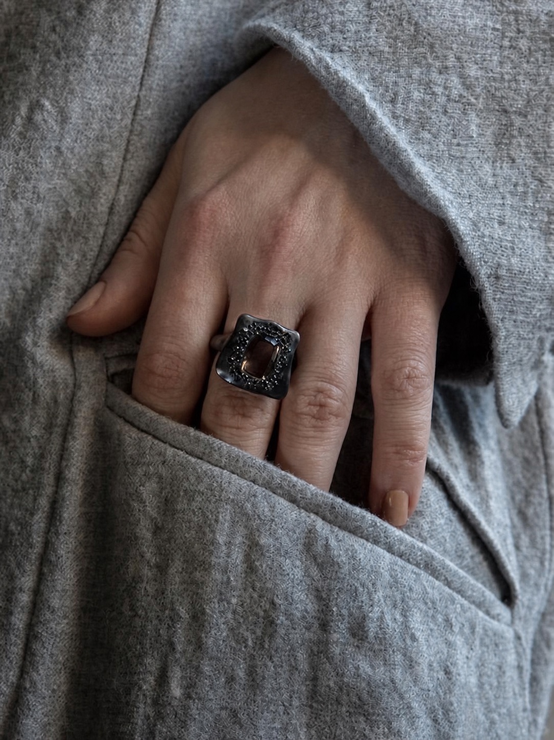 Rosa Maria square ring worn with a grey knit sleeve
