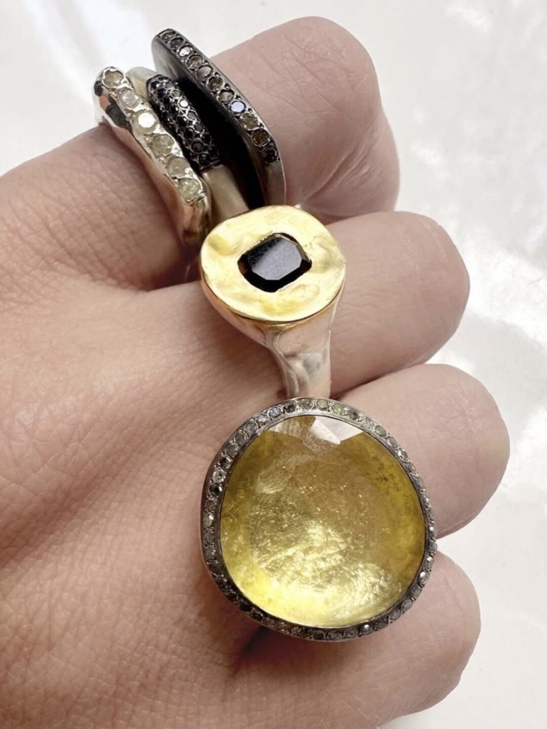 Rosa Maria rings with a yellow stone on a white background