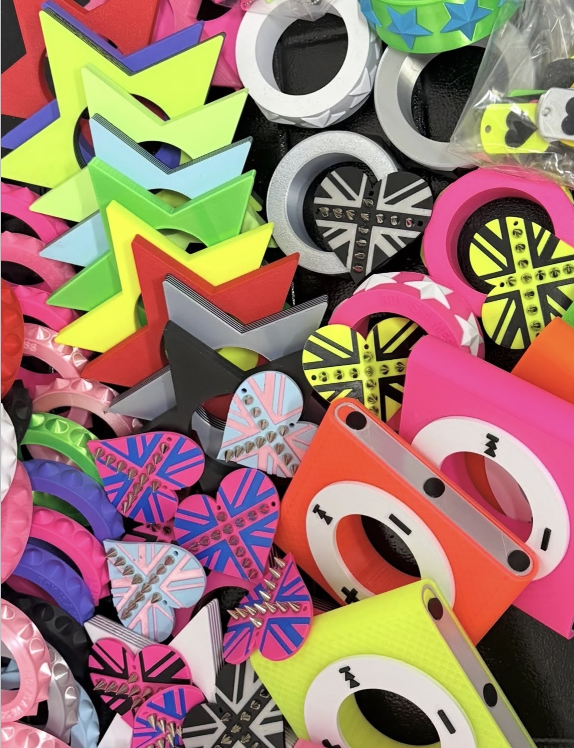 Pile of neon star and iPod bangles with studded heart shapes decorated in Union Jack patterns.