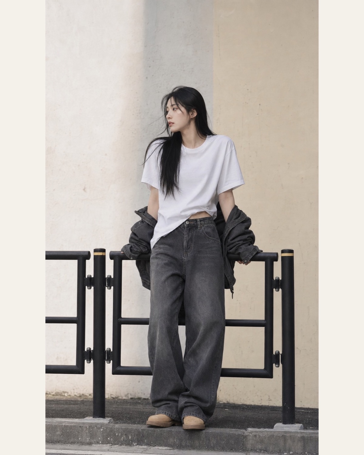 Loose white T-shirt, grey wide-leg jeans and a dark jacket slipped off the arms