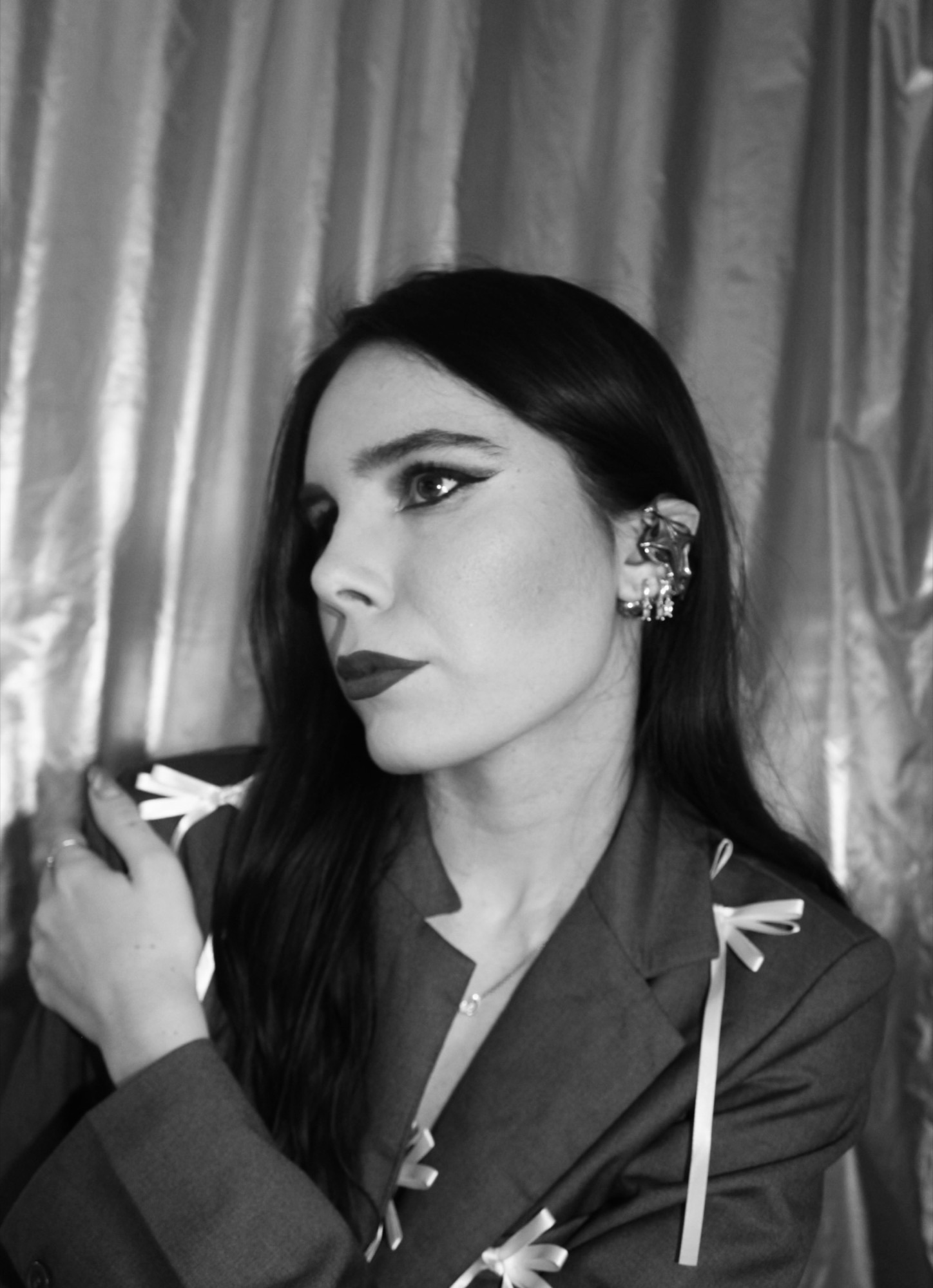 Side-profile portrait showing a metallic star-shaped open earphone reading clearly against the face and neck.