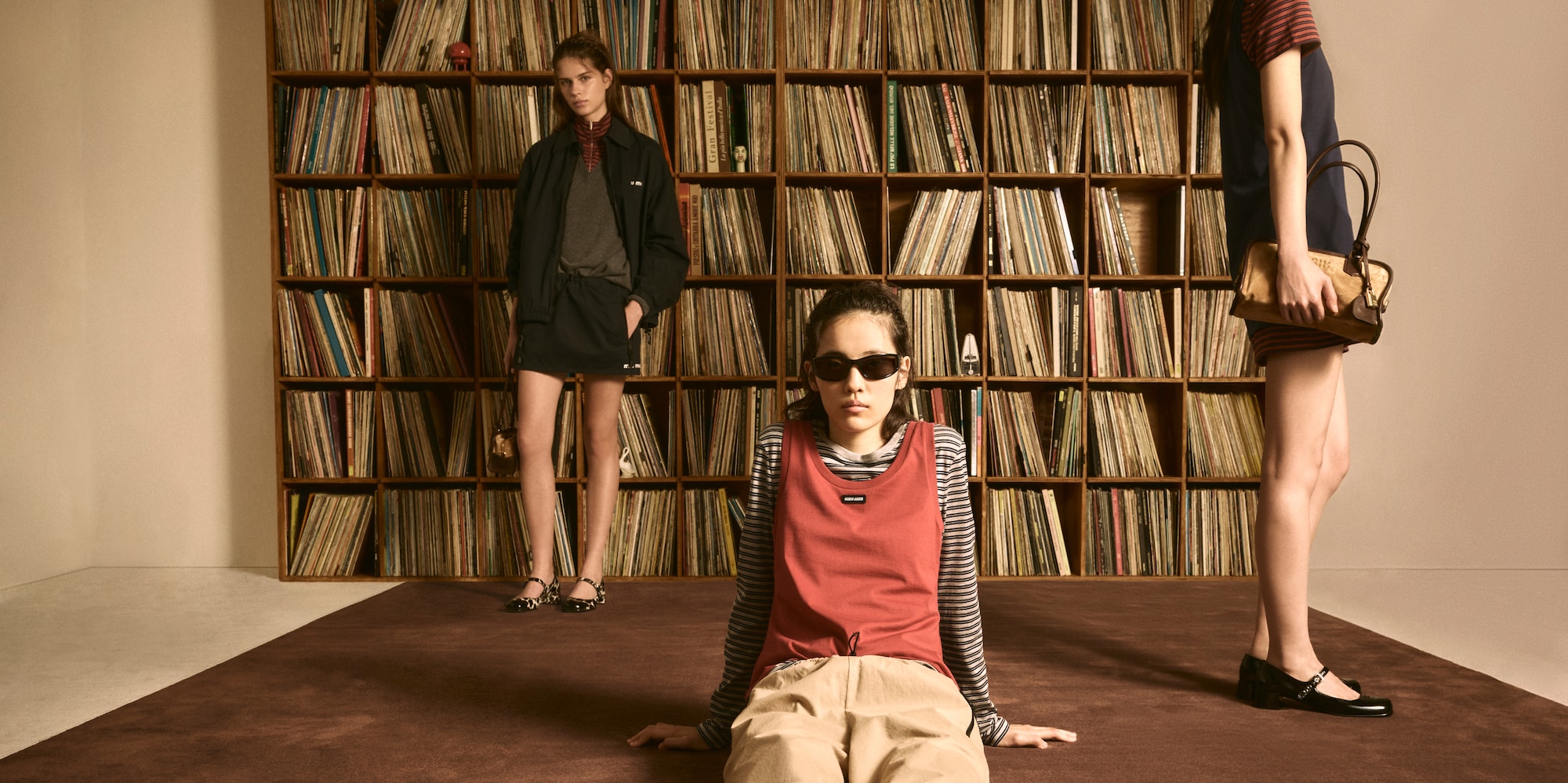 Miu Miu Vinyl Club pop-up with fashion looks and a wall of vinyl records.