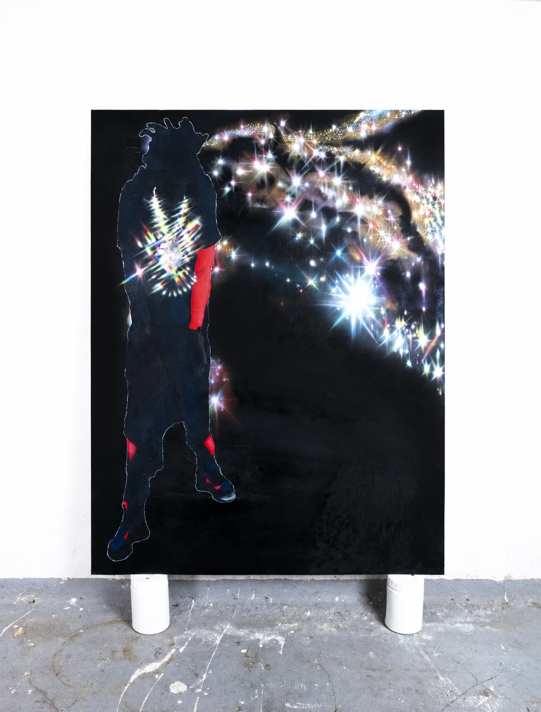 Dark figure outlined by multicoloured light and starbursts on a black artwork