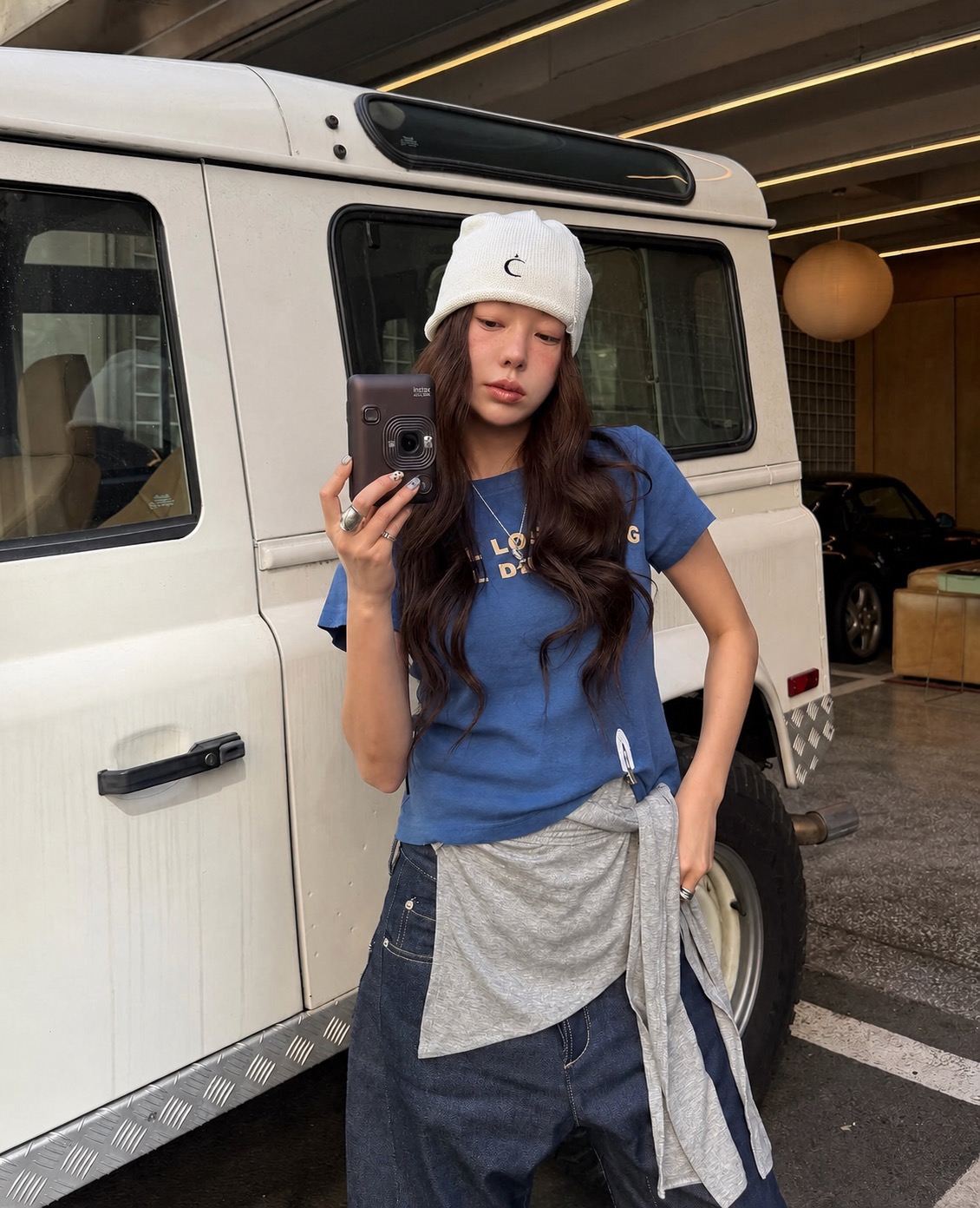 A casual sporty outfit with a cap, loose layers, and grounded street styling