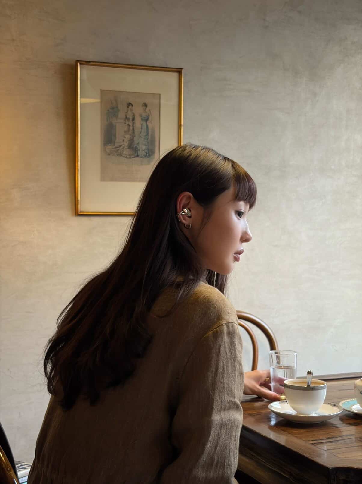 Instagram street-style portrait of a wearer styling a silver open earphone with an all-black outfit.