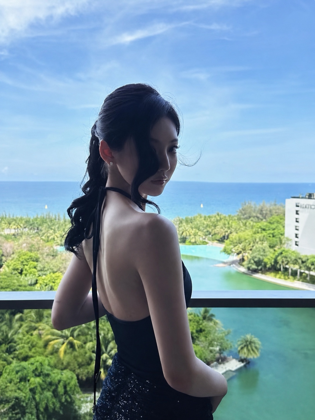 Dark feminine vacation styling with black backless outfit and controlled silhouette