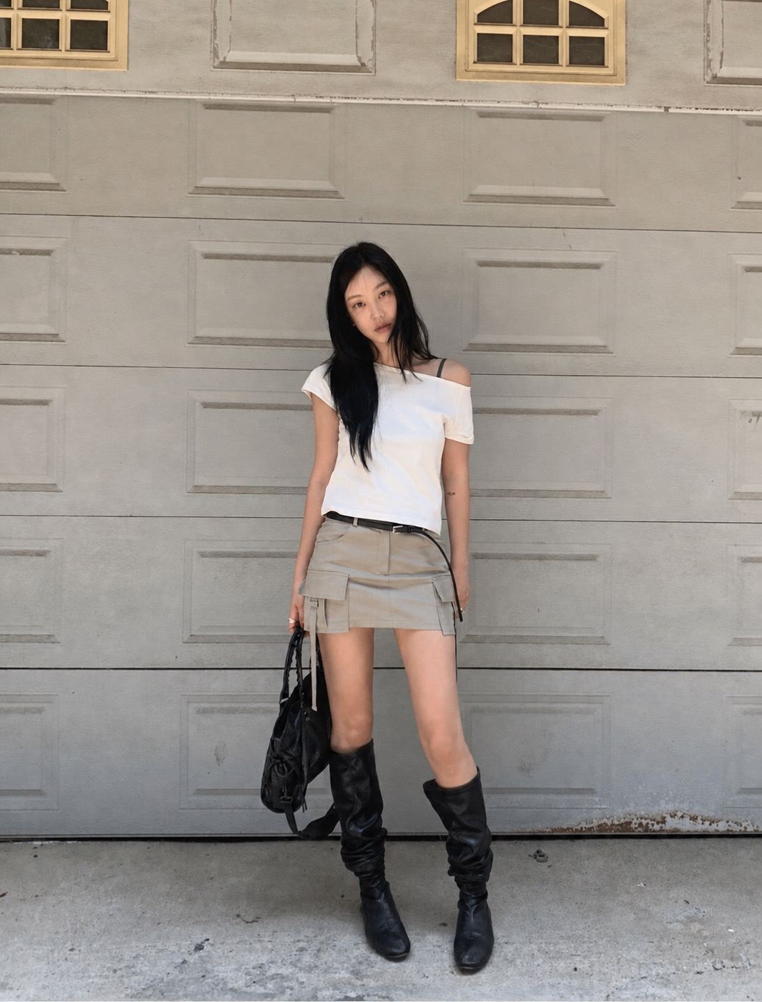 A white oversized top with grey sweats and grounded casual accessories