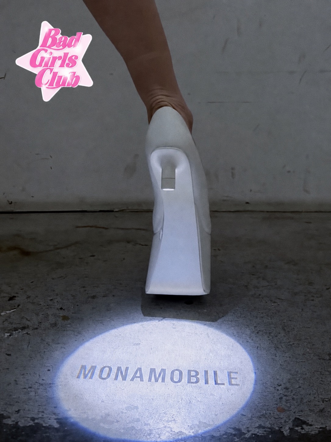 A white LED heel casting a Monamobile projection on the floor.