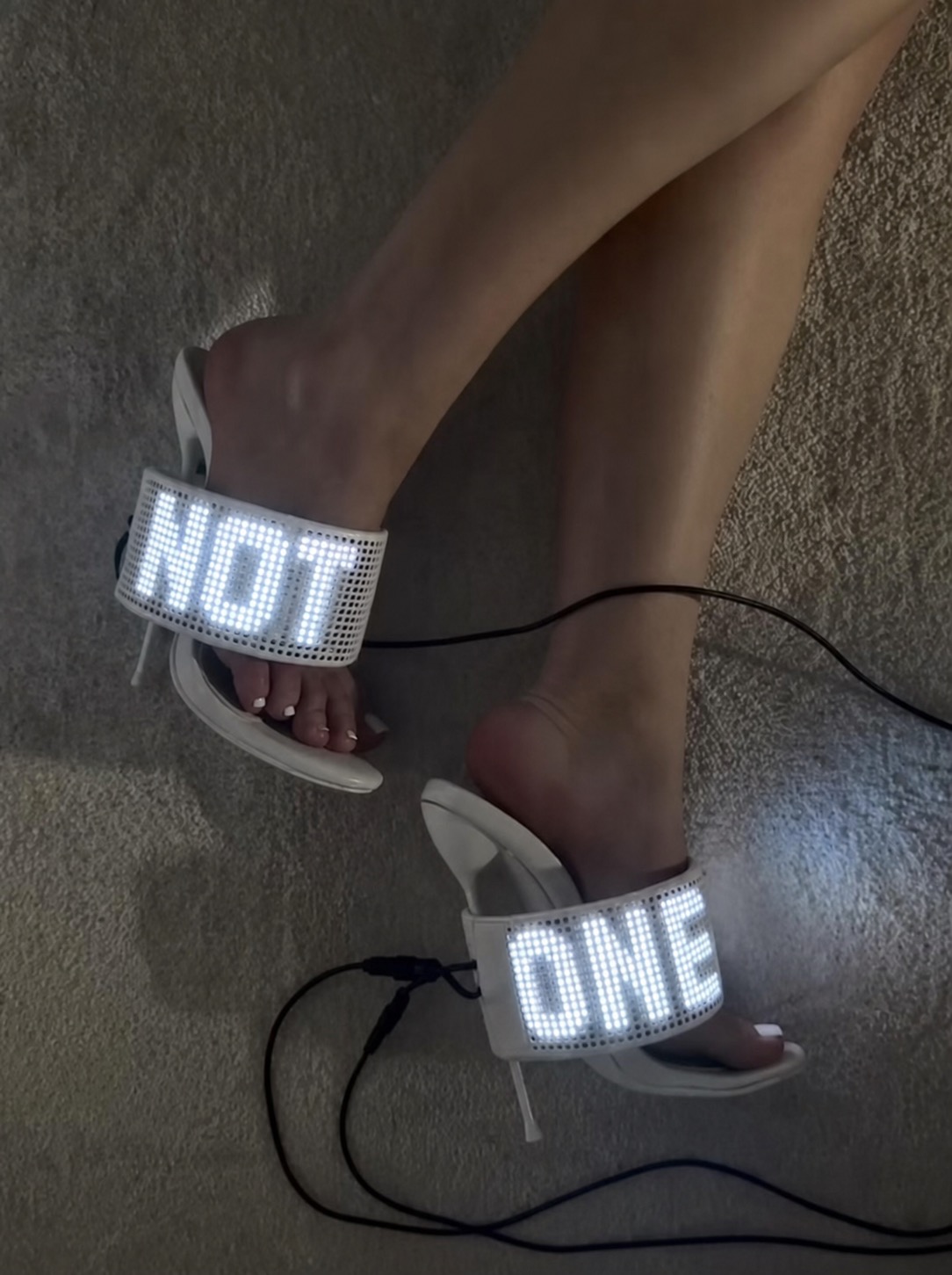 LED heeled sandals displaying text across the front strap.