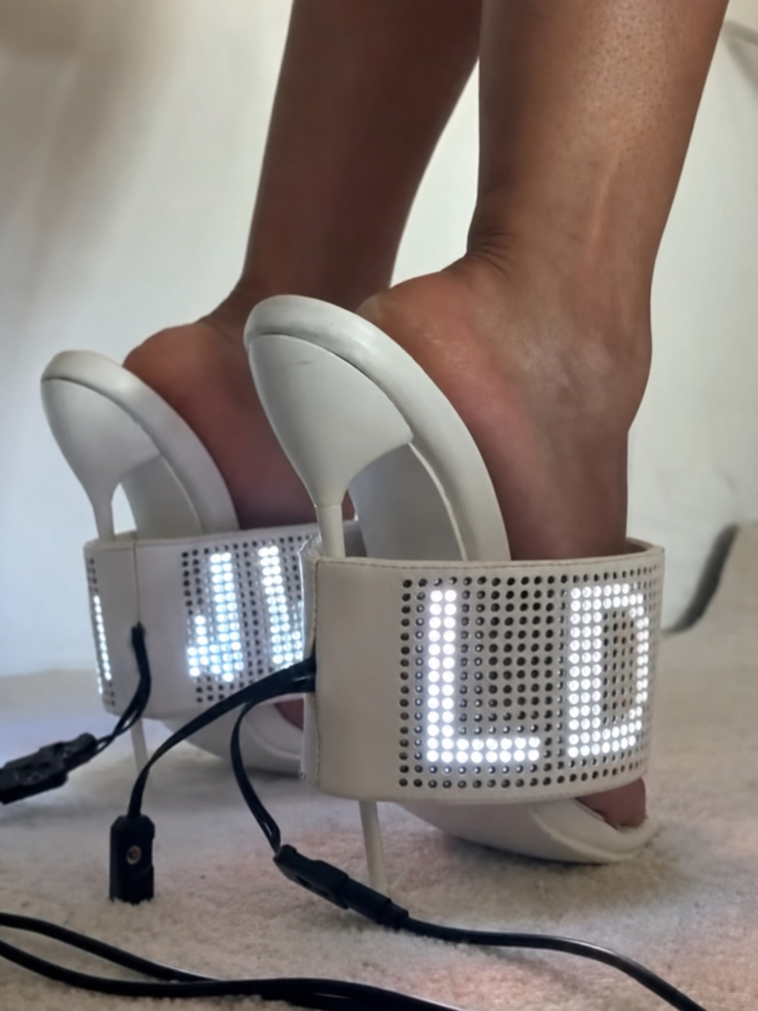 White LED heels with illuminated digital text built into the back straps.