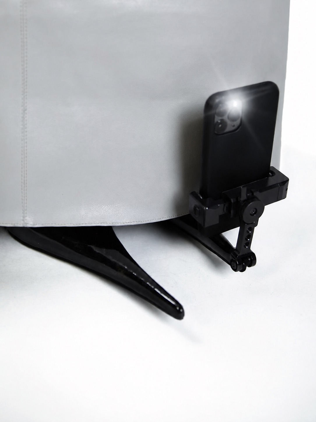 A phone clipped to the hem of a white skirt, turning clothing into a display surface.