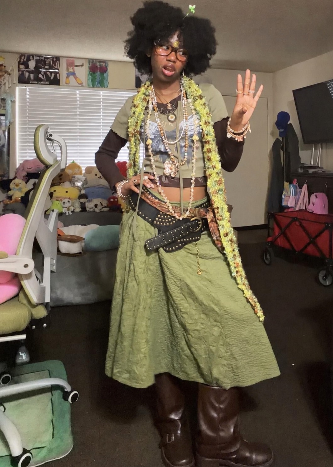 Olive-green dress styled with a large knit wrap, boots, and layered necklaces