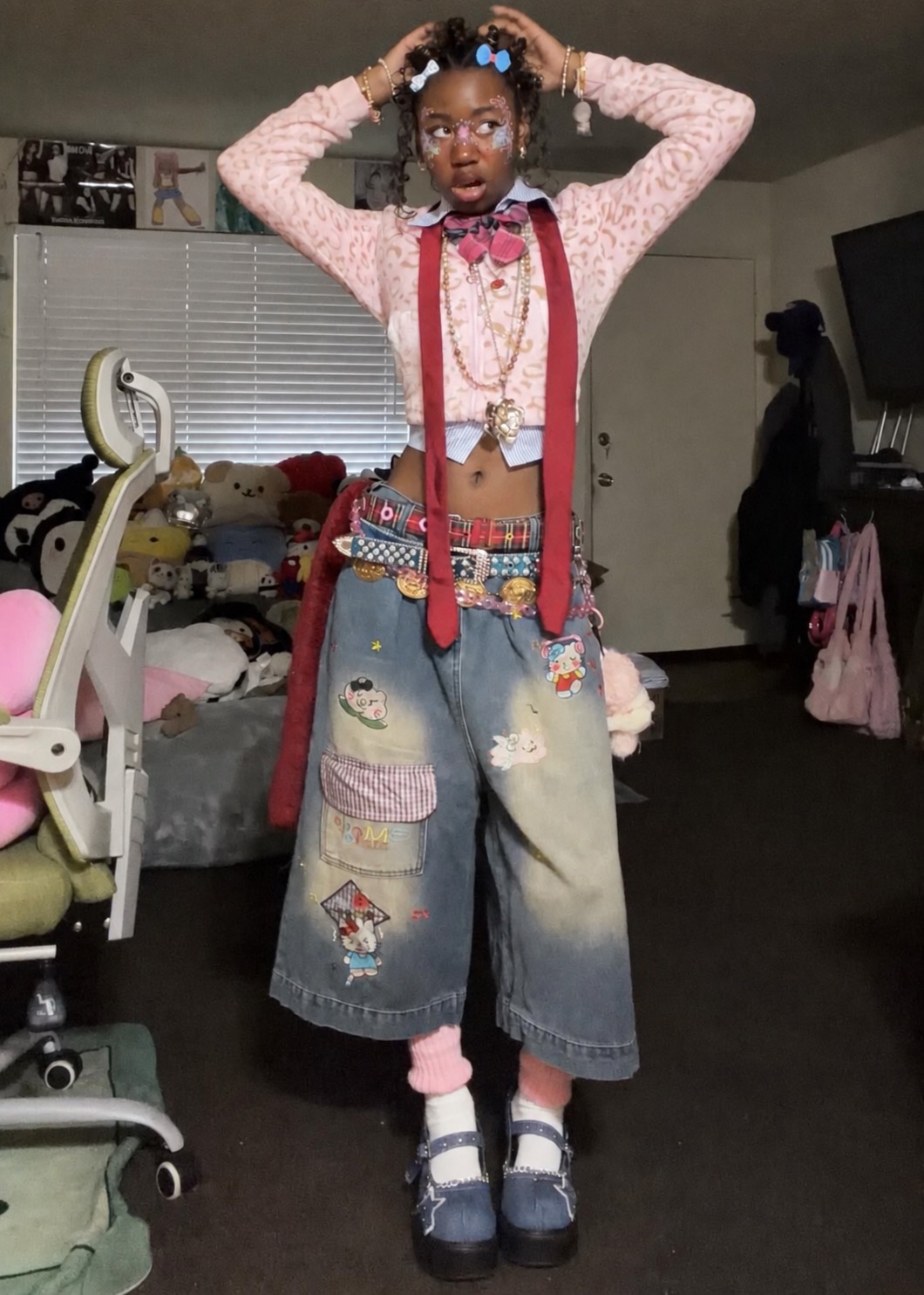Pink crop top and patchwork jeans covered with bows, badges, belts, and playful details