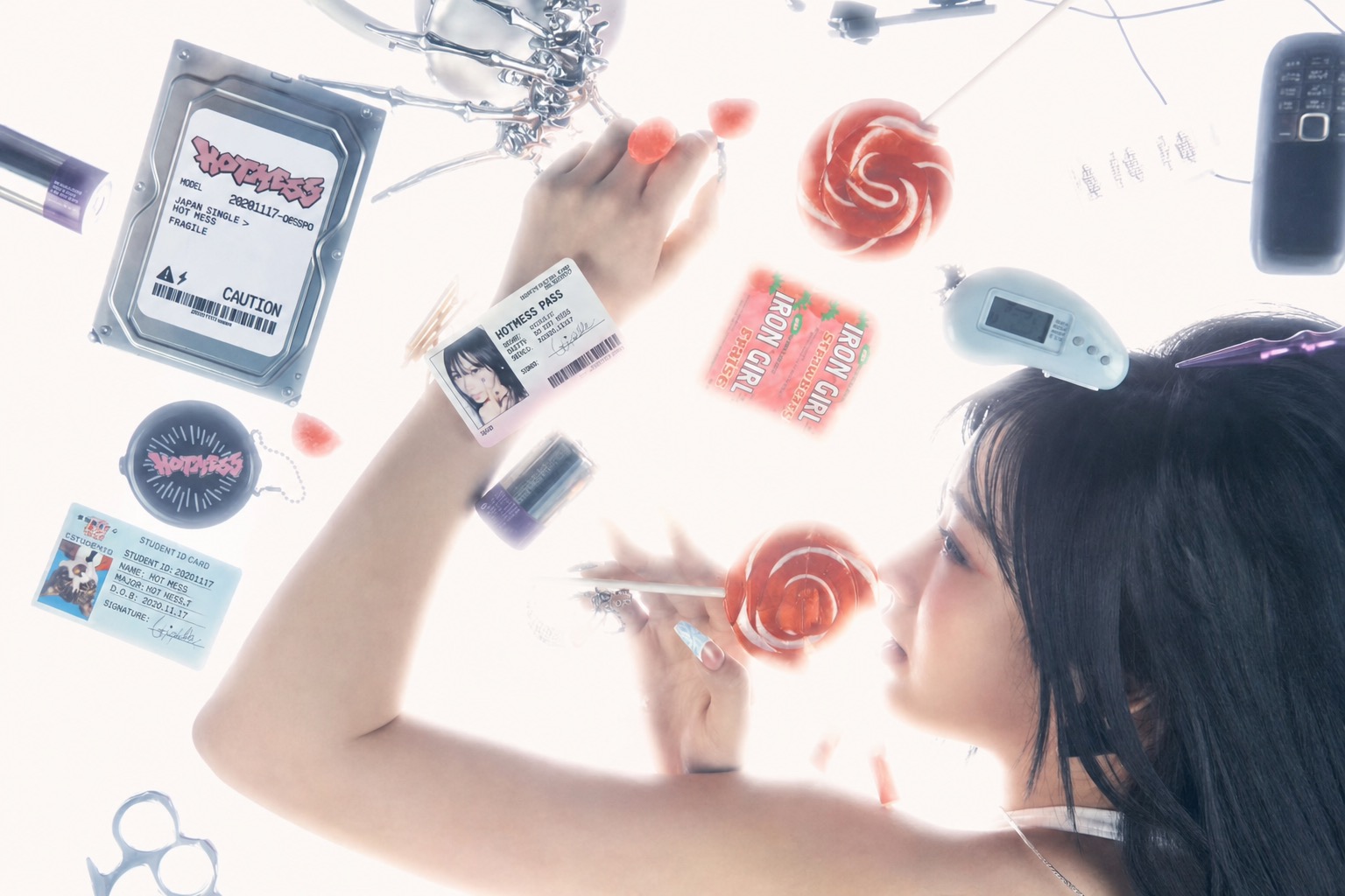 bright cyber Y2K close-up with lollipops, ID cards, tech props, and glossy styling